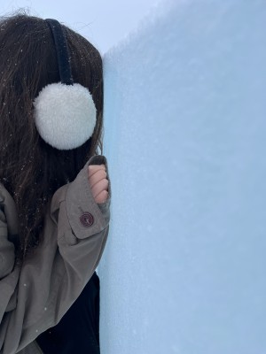 A person with long dark hair touching a ice. 